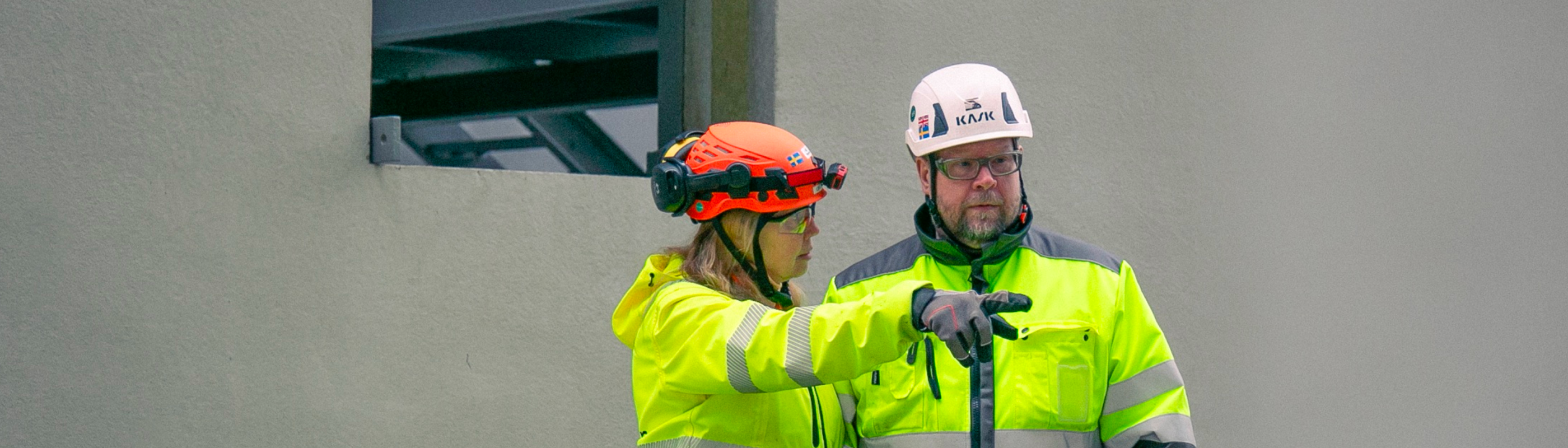 Två personer i varse- och skyddskläder på site.